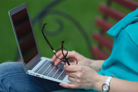 Girl using a laptop on a benchの写真素材