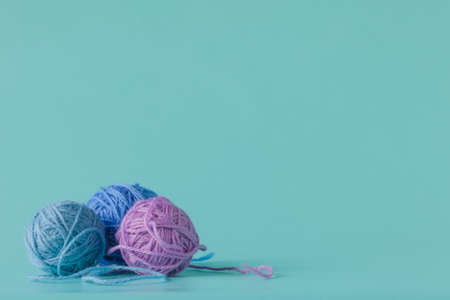 Woolen yarn in balls on a aquamarine background