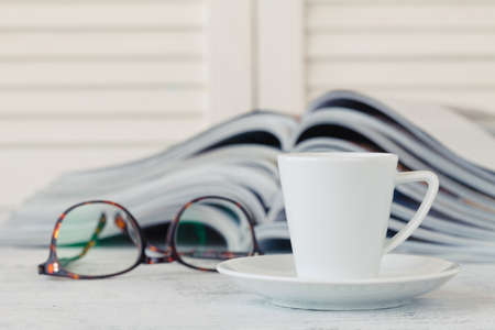 Stack of magazines and newspaper open page on tableの写真素材