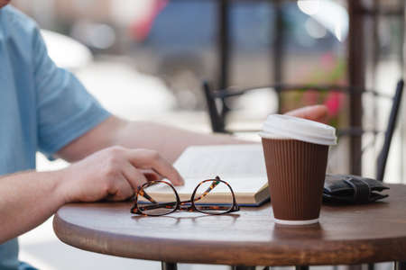 man reading book with coffee or tea