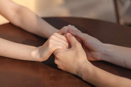 Loving couple holding hands on table in cafe