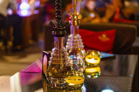 bar for smoking a hookah. The background is blurred. In the foreground is a big hookahの写真素材