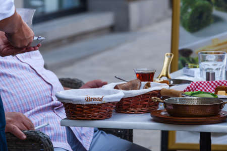 Waiter serving tea to customer in street cafeの写真素材