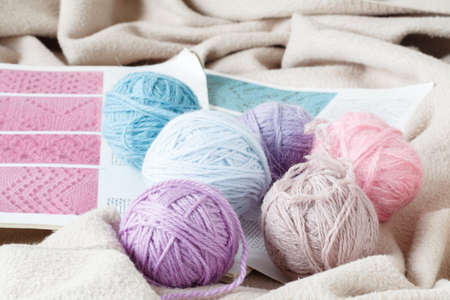 balls of pink and gray yarn, knitted fabric on a woolen background