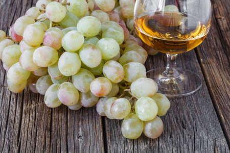 Glass of brandy on wooden table in autumt eveningの写真素材