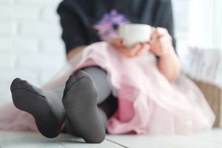 Beautiful girl with hot drink relaxing at homeの写真素材