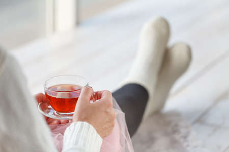Beautiful woman drinking a cup of tea in bedroom in the morningの写真素材