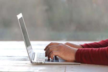 Handsome young man laying on floor at home, browsing internetの写真素材