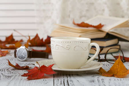 Autumn leaves and black coffee composition. coffee cup at weathered rustic wood background. Fall hot drinks conceptの写真素材