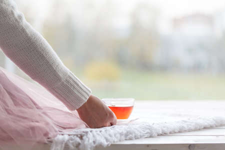 Beautiful woman drinking a cup of tea in bedroom in the morningの写真素材