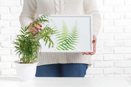 Young woman in wooden interior hoding frame with her sketch. art conceptの写真素材