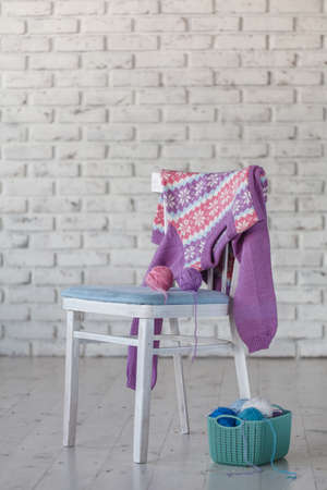 baby girl sweater hanging on white brick wall backgroundの写真素材