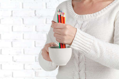 Woman hold mug with many color pencilの写真素材