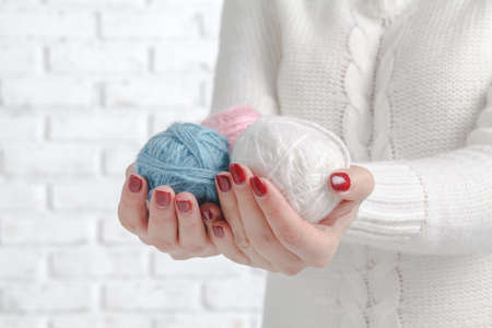 Hands holding a balls of yarn