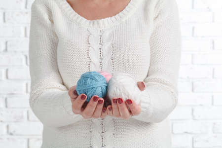 female hands holding stitching, yarn, thread close up. materials for handmade and handiworkの写真素材