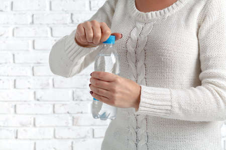 hands opening bottle with waterの写真素材