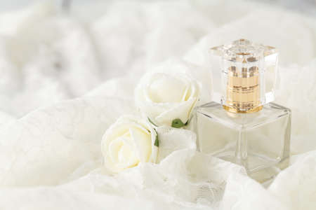 glass scent bottle on ladies dressing table with shabby schic pearl necklace and lacesの写真素材
