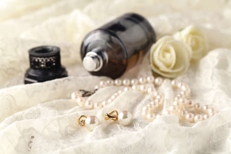 women's perfume in beautiful bottle, light background with accessories for the care and beautyの写真素材