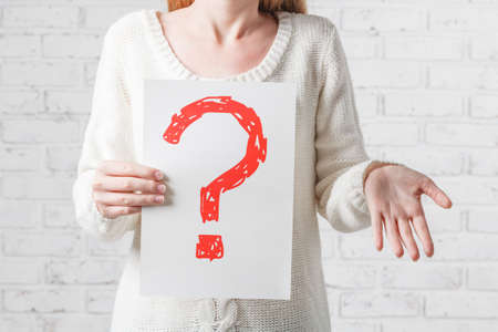 Girl in white having no answers to a question.の写真素材