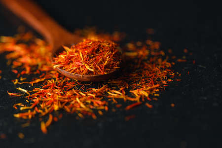 Saffron in a spoon on a dark background, selective focus, macro shot, shallow depth of fieldの写真素材
