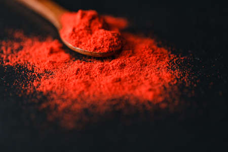 Organic Pink Peppercorn in wooden spoon on black slate stone backgroundの写真素材