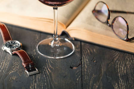 Open book with wine glass on a wooden backgroundの写真素材