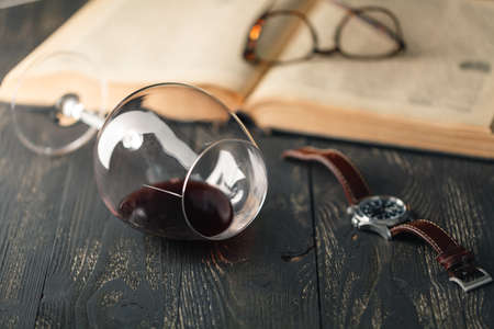 Open book with wine glass on a wooden backgroundの写真素材