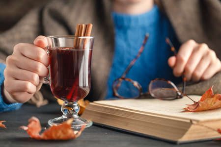 Woman holding mug of hot drink (apple tea, mulled wine). Female hands with cup of seasonal hot drink. Homemade hot fruit tea.の写真素材