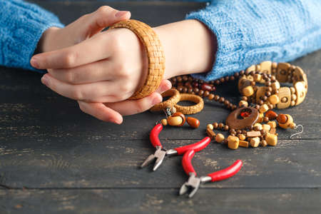 Making of handmade jewellery. Box with beads and glass hearts on old wooden background. Handmade accessoriesの写真素材