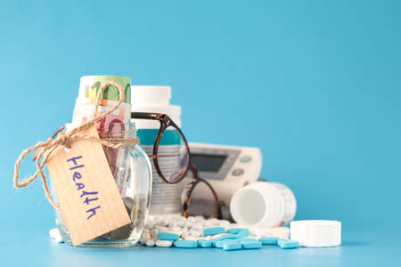 Saving money for health care insurance - money glass, pills and bottlesの写真素材