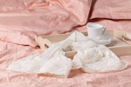 wooden tray with light breakfast on bed on the bed with white linenの写真素材