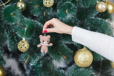 girl decorate the Christmas tree in a house interiorの写真素材