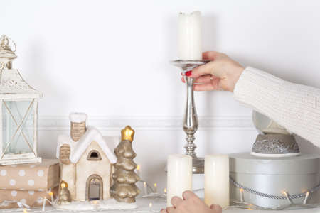 Fireplace mantle is decorated for Christmas with garland, lights, a bow and other decorations.