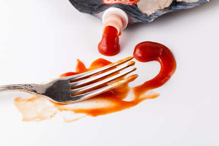 Fork stained tomato ketshup on table with dishの写真素材