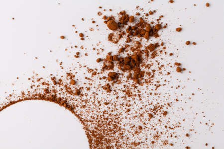 Circle of cocoa powder on white table
