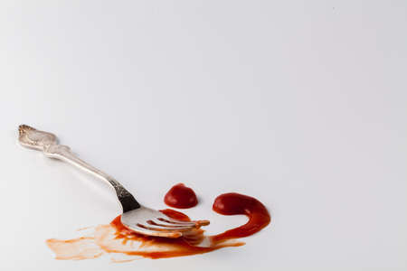 Ketchup stain on a white background with fork
