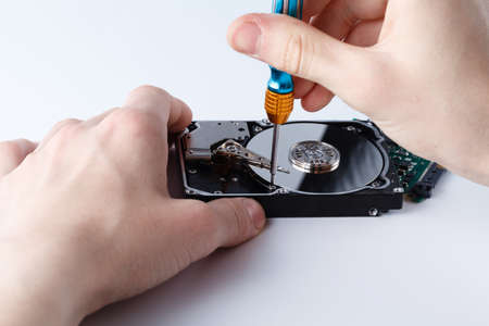 Hard disc drive disassembling close up. Repairman opening hdd for recovery information