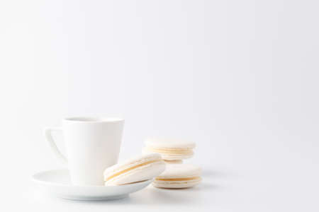 One small cup of espresso with white macaroon, copy space