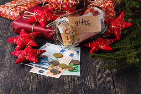 Save money for gift concept, open glass jar with banknotesの写真素材