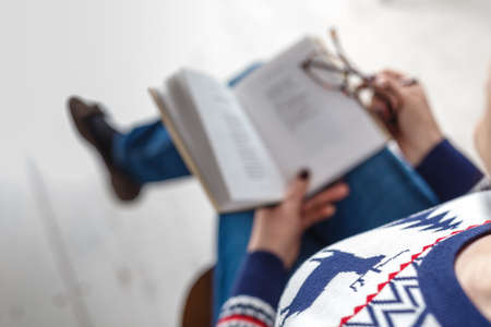 adult woman with glasses reading a bookの写真素材