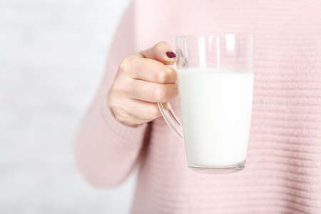 a woman gives you a cup of milkの写真素材