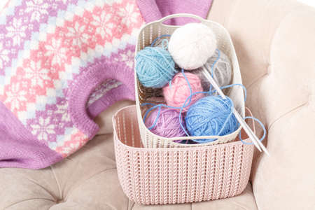 Knitting baby things, close up colored clew in hand