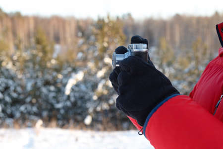 Vintage camera in hand, outdoor winter with sky