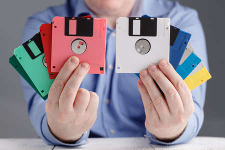 Male hold floppy disk in hands, retro storageの写真素材