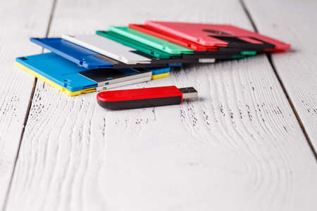 Pile of retro floppy disk versus usb flash driverの写真素材