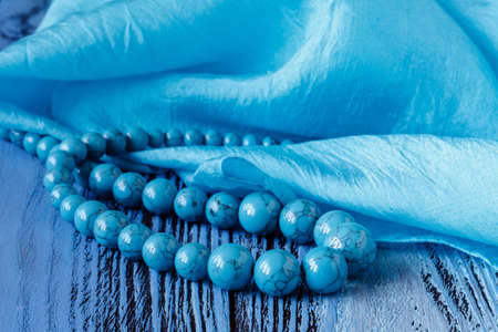 turquoise beads on blue wooden backgroundの写真素材