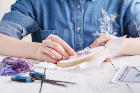Hands embroidering a flower. Cross-Stitch.の写真素材
