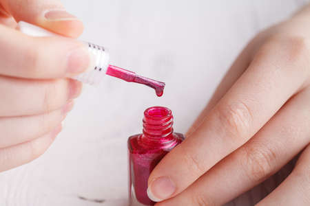 Bottles with nail polish in female handsの写真素材