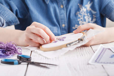Hands embroidering a flower. Cross-Stitch.の写真素材