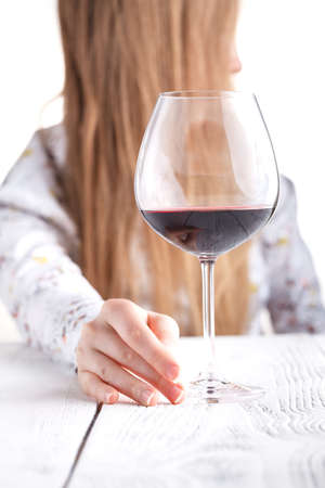 Young woman with a glass of wine. Addicted to drugs and alcohol.の写真素材